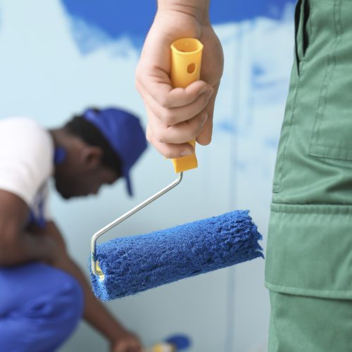 Male painters doing repair in room, closeup